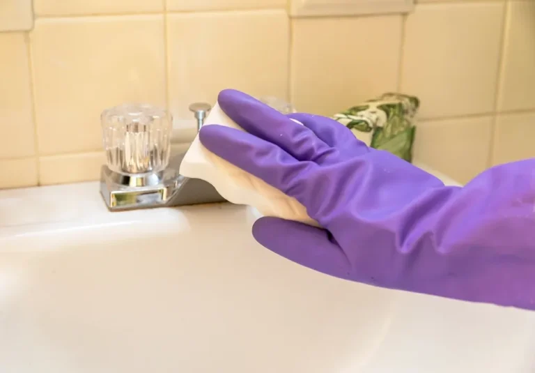 Limpieza de un fregadero con guantes