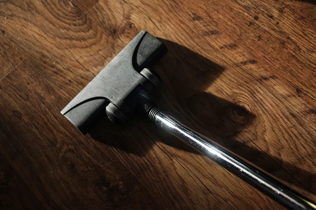 Cabezal de un aspirador sobre un suelo de madera