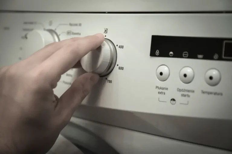 Mano girando el selector de una lavadora