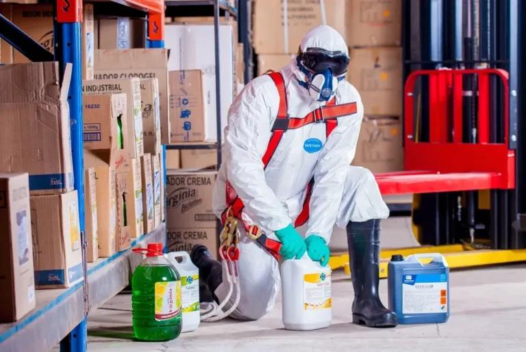 Operario con equipo de protección desinfectando una zona de trabajo