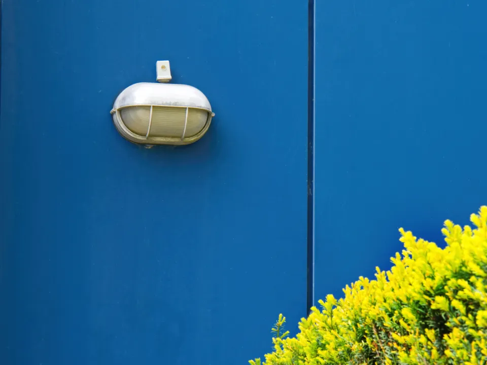 Lámpara de exterior sobre una pared azul