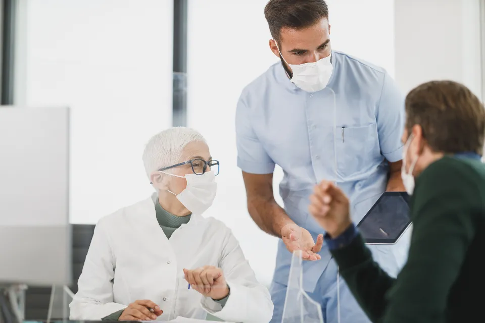 Profesional sanitaria con mascarilla atendiendo a un paciente
