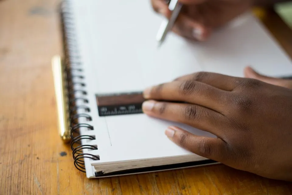 Mano escribiendo en un cuaderno