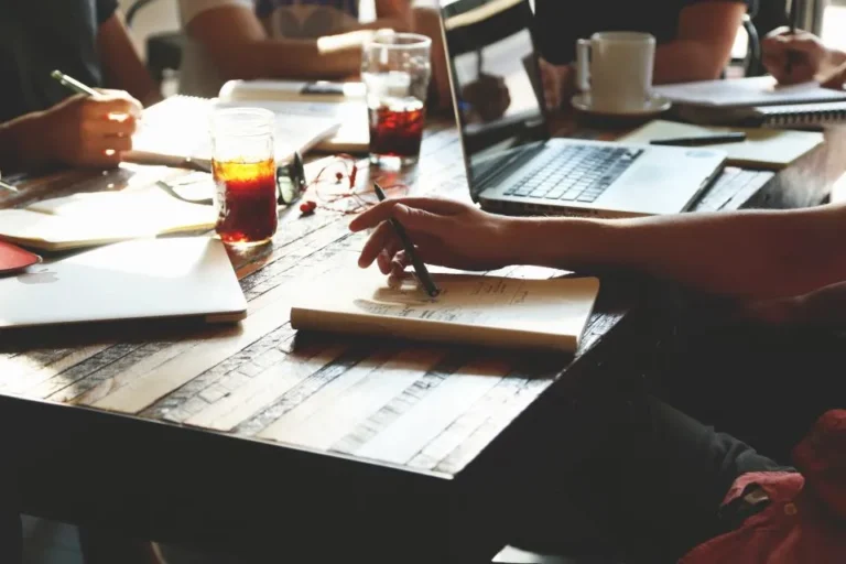 Manos sobre documentos en una reunión