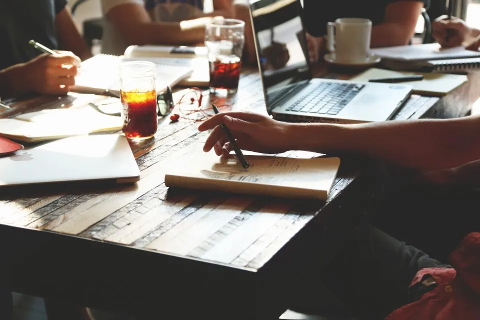 Manos sobre documentos en una reunión