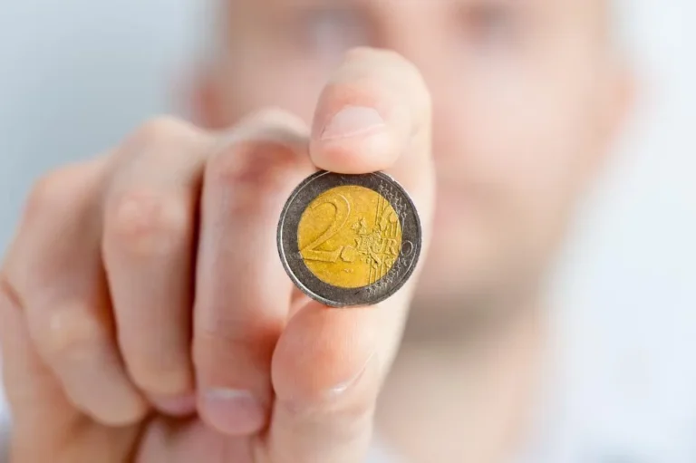 Mano sujetando una moneda de euro