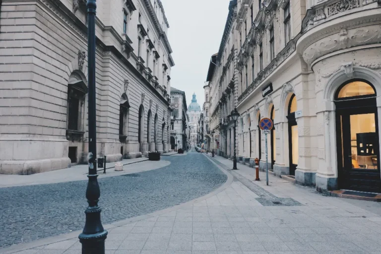 Calle peatonal limpia y vacía entre edificios de piedra en el centro de una ciudad